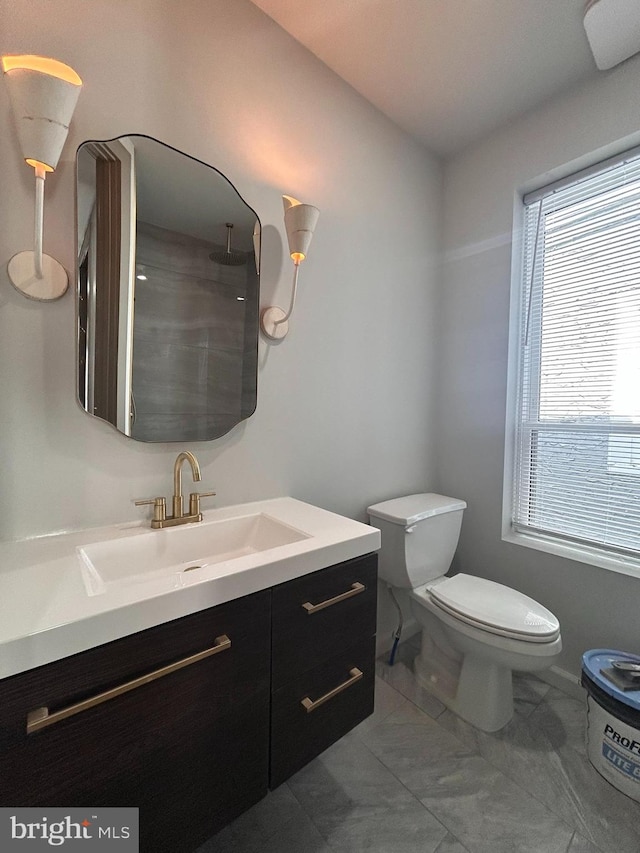 bathroom featuring walk in shower, vanity, and toilet