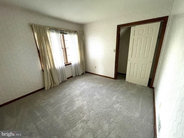 unfurnished bedroom with a closet and light colored carpet