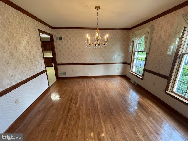 unfurnished dining area with hardwood / wood-style flooring, a wealth of natural light, and a chandelier