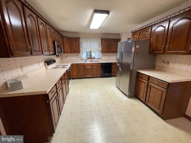 kitchen featuring dark brown cabinetry, stainless steel appliances, and sink