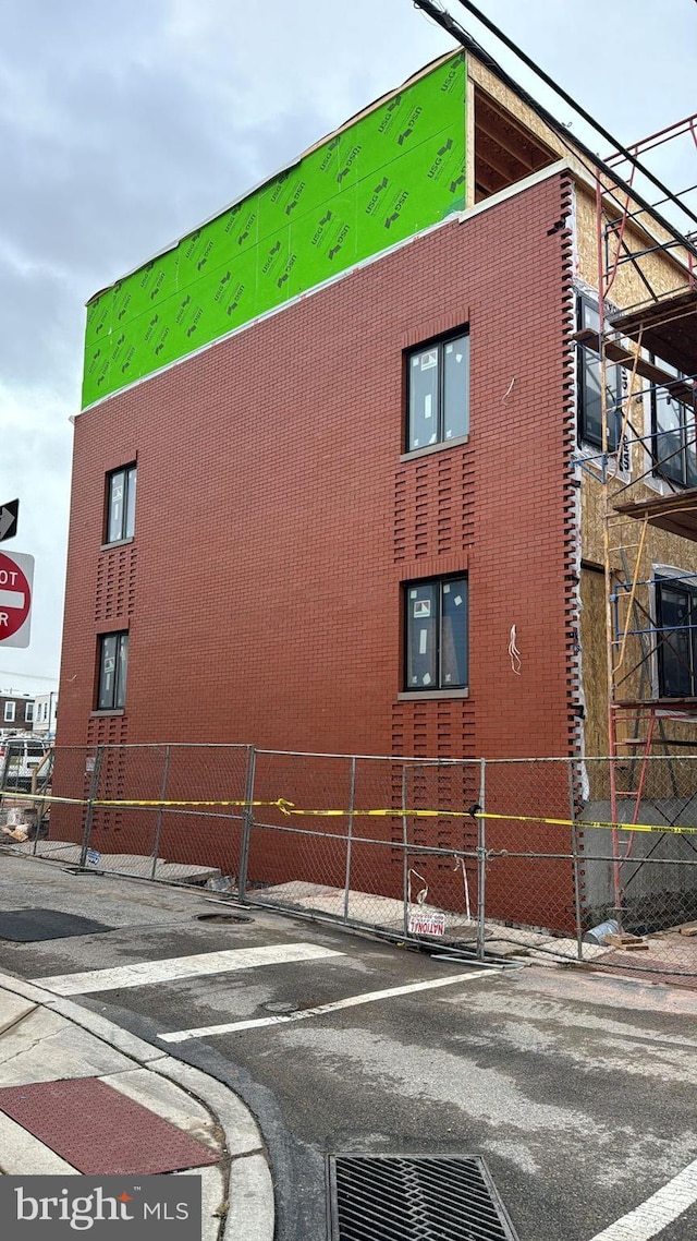 view of building exterior featuring uncovered parking and fence