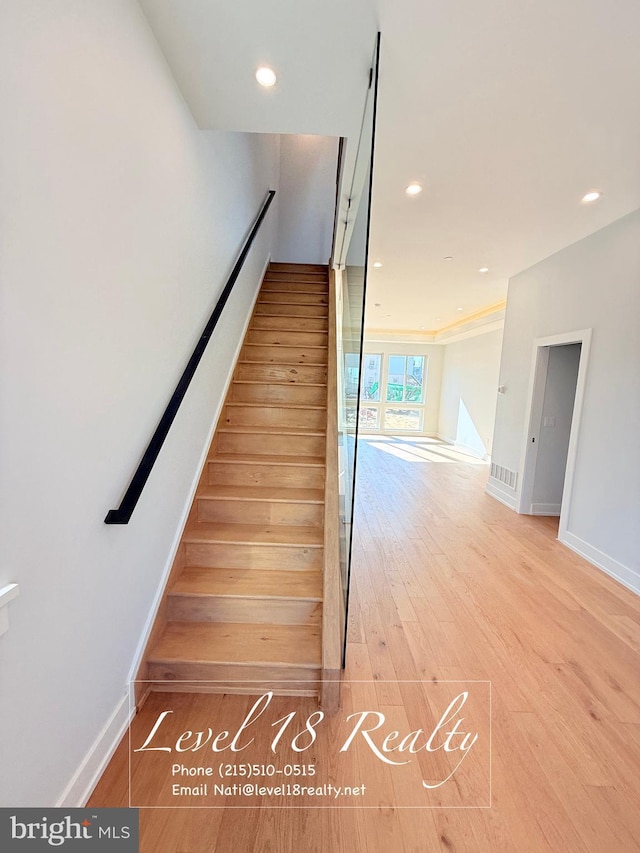 stairway featuring recessed lighting, baseboards, and wood finished floors