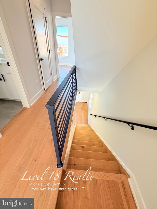 stairway with baseboards and wood finished floors
