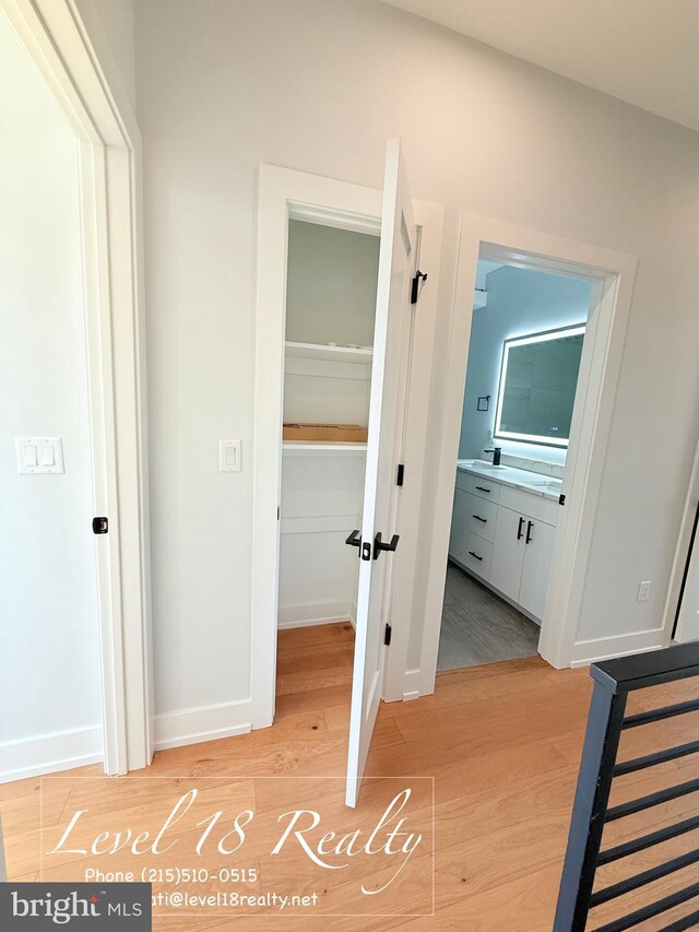 corridor with baseboards, french doors, and light wood finished floors
