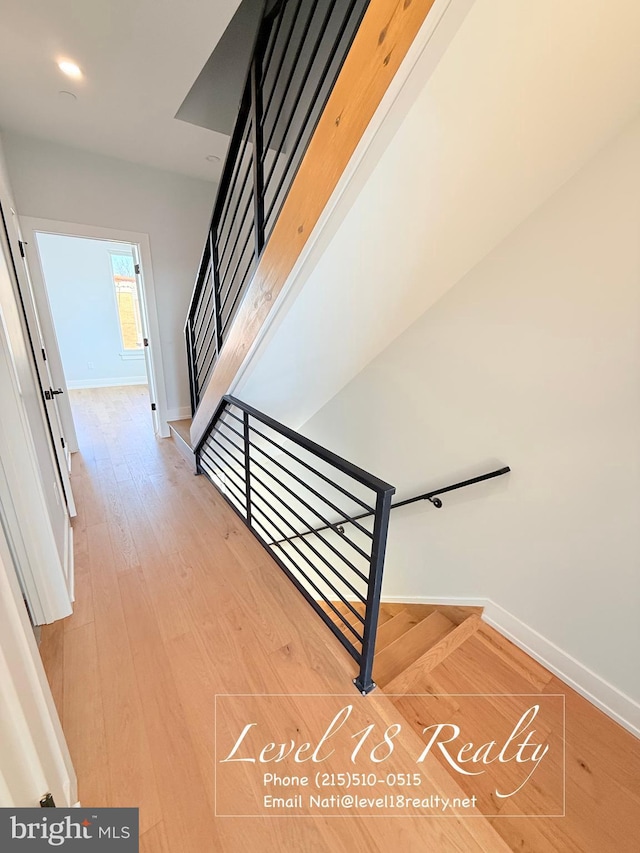 stairs with baseboards and wood finished floors