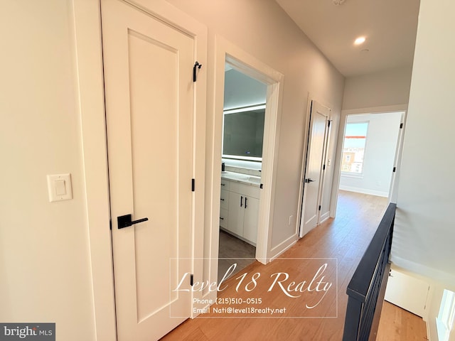 hall featuring baseboards, wood finished floors, and recessed lighting