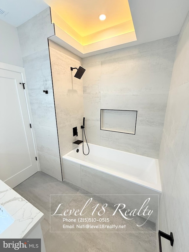full bath featuring recessed lighting, tiled shower / bath, a tray ceiling, and visible vents