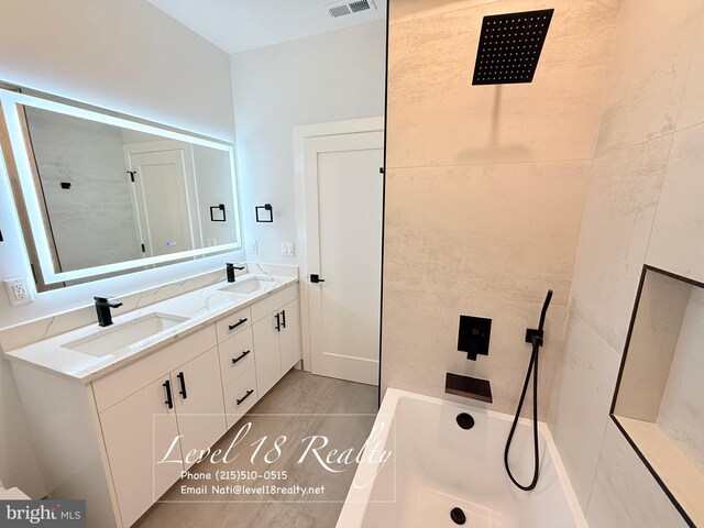 full bathroom with double vanity, a sink, visible vents, and walk in shower