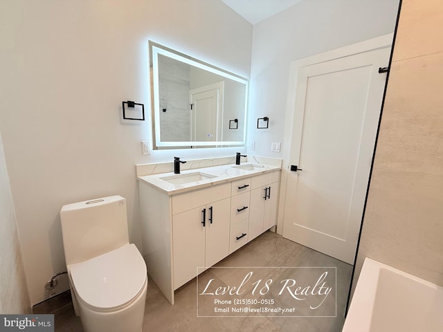 full bath featuring double vanity, a sink, and toilet