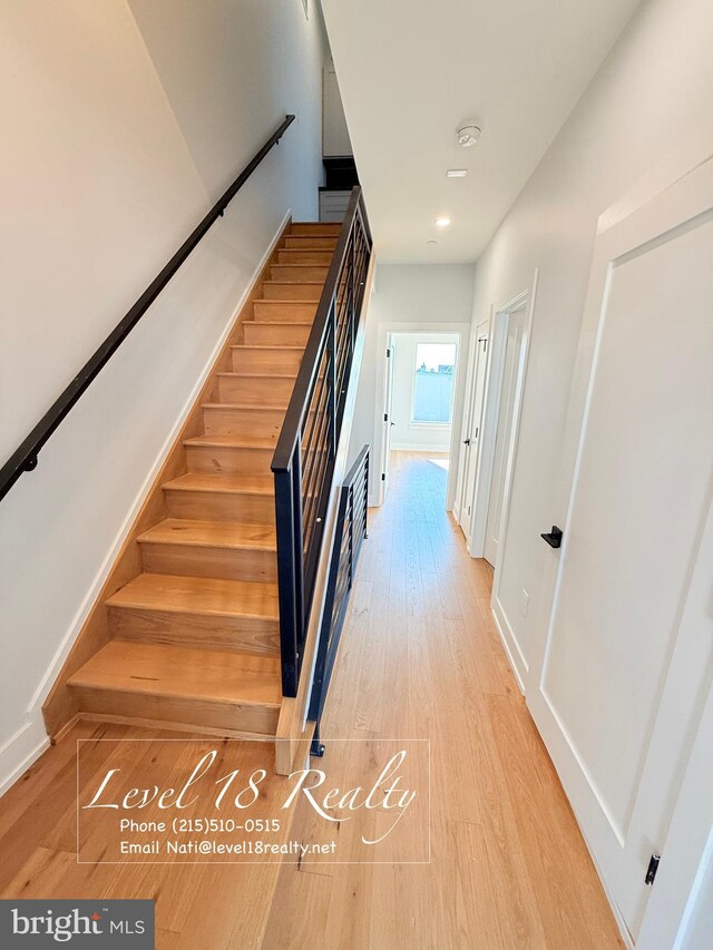 stairway with baseboards and wood finished floors