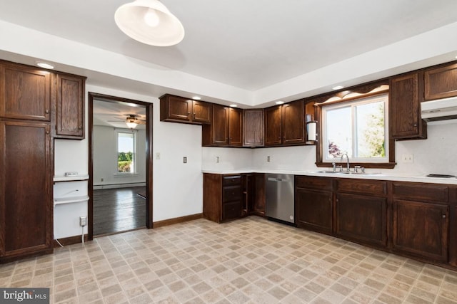 kitchen featuring dishwasher, a sink, light countertops, under cabinet range hood, and baseboards