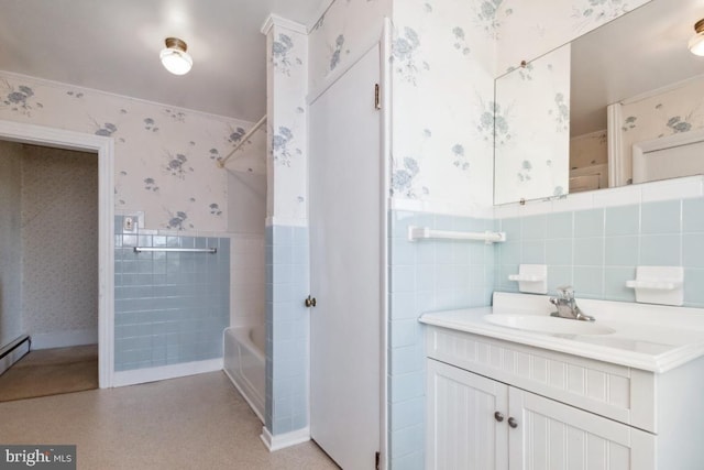 bathroom featuring wallpapered walls, tile walls, wainscoting, vanity, and washtub / shower combination