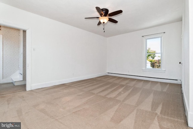 empty room with a baseboard heating unit, light colored carpet, and ceiling fan