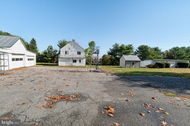 view of front of house with a storage shed and a front lawn