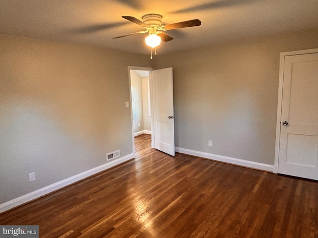 spare room with ceiling fan and dark hardwood / wood-style flooring