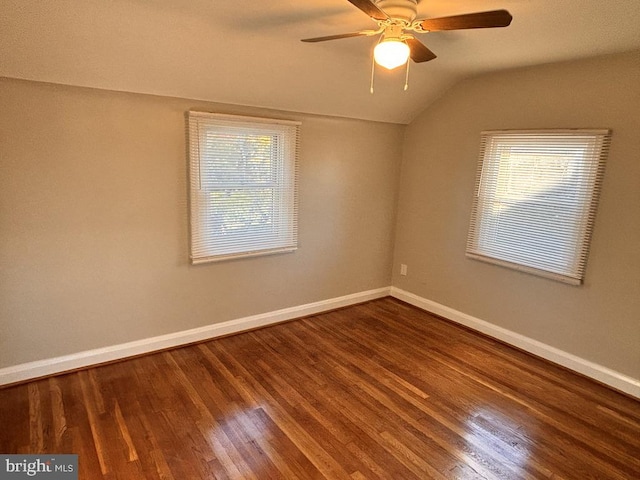 spare room featuring lofted ceiling, hardwood / wood-style flooring, ceiling fan, and a healthy amount of sunlight