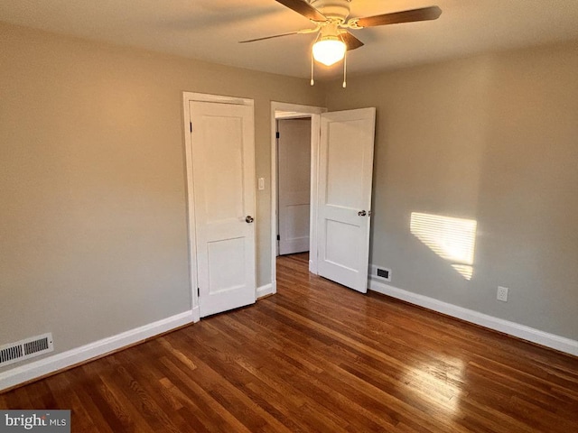 empty room with dark hardwood / wood-style flooring and ceiling fan