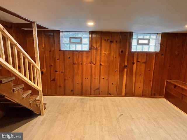 basement featuring hardwood / wood-style floors and wood walls