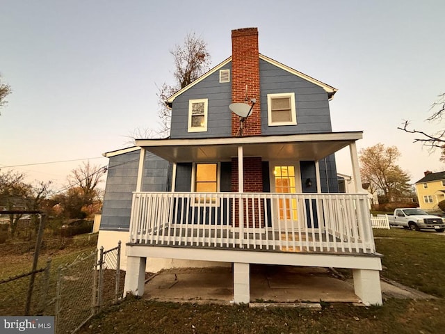 back house at dusk with a porch