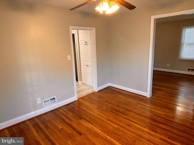 spare room featuring ceiling fan and dark wood-type flooring