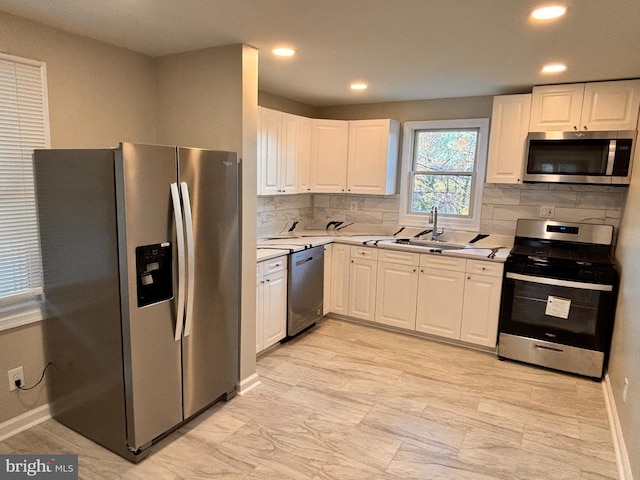 kitchen featuring decorative backsplash, white cabinetry, sink, and stainless steel appliances