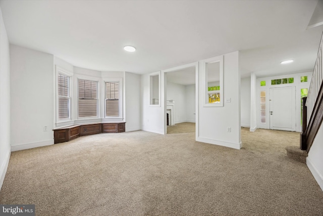 unfurnished living room featuring light carpet