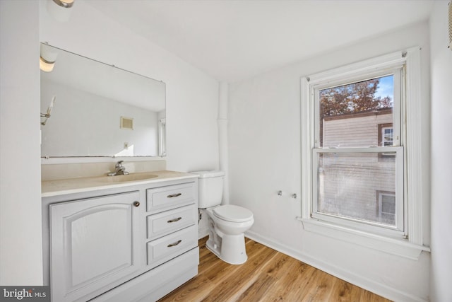 bathroom with hardwood / wood-style floors, vanity, and toilet