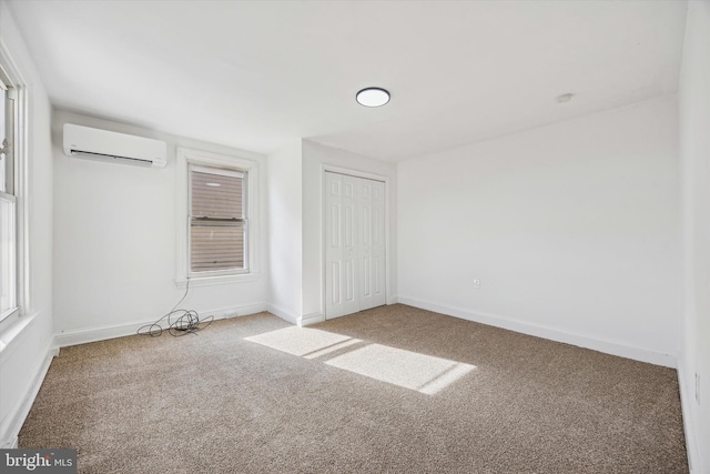 unfurnished bedroom featuring multiple windows, carpet flooring, and a wall mounted air conditioner