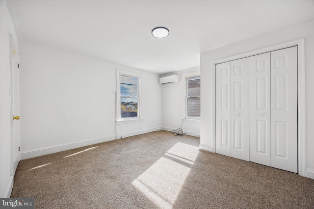 unfurnished bedroom with carpet flooring, a closet, and a wall mounted air conditioner