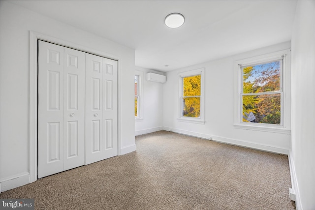 unfurnished bedroom featuring carpet, an AC wall unit, and a closet