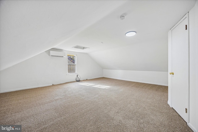 additional living space featuring carpet, vaulted ceiling, and a wall unit AC