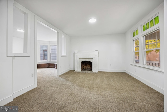 unfurnished living room with a wealth of natural light, carpet, and a fireplace