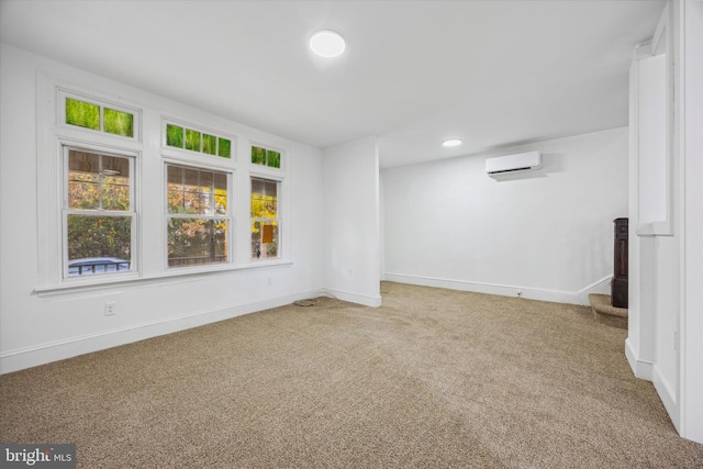 carpeted spare room with a wall unit AC