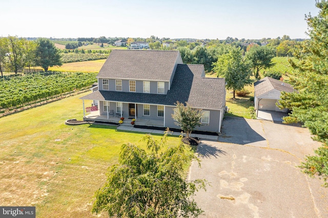 view of front of property with a rural view, an outbuilding, a front lawn, and a garage