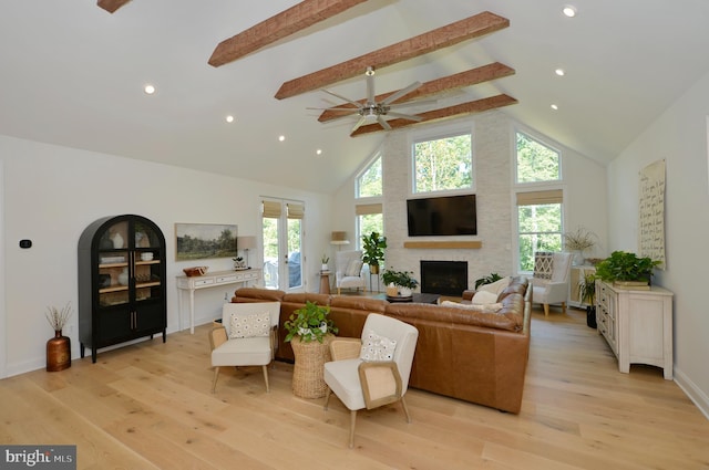 living room featuring light wood-type flooring, plenty of natural light, and high vaulted ceiling