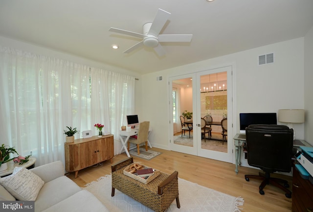 home office featuring french doors, ceiling fan, and light wood-type flooring