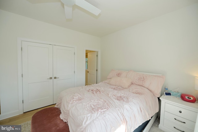 bedroom featuring a skylight, a closet, light hardwood / wood-style floors, and ceiling fan