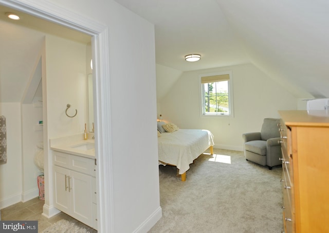 carpeted bedroom featuring sink and vaulted ceiling