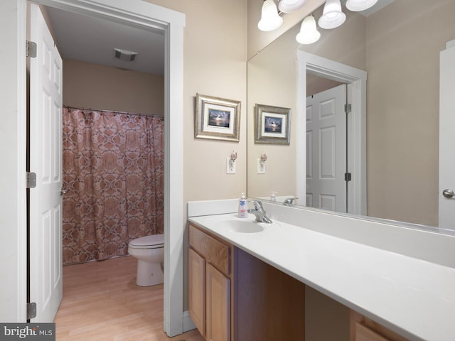 bathroom with hardwood / wood-style floors, vanity, and toilet