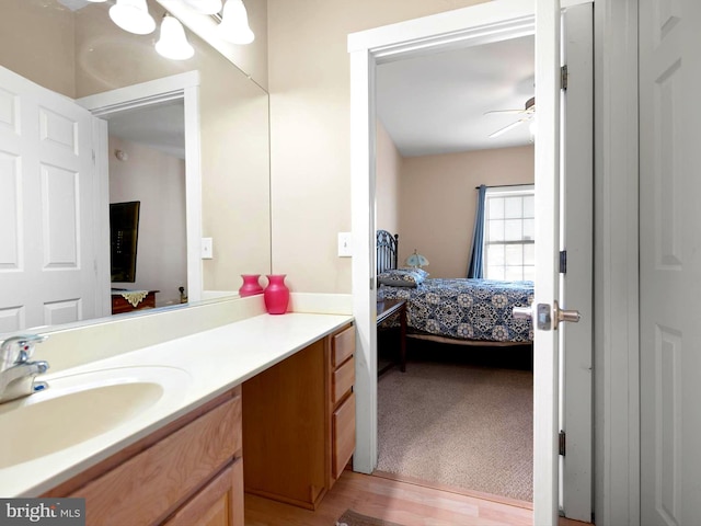 bathroom with hardwood / wood-style floors, ceiling fan, and vanity