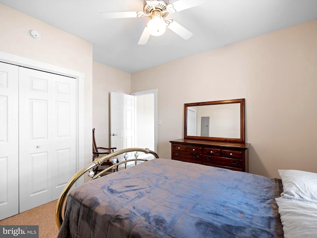 carpeted bedroom featuring ceiling fan and a closet