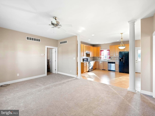 kitchen with pendant lighting, light carpet, ceiling fan, ornate columns, and stainless steel appliances