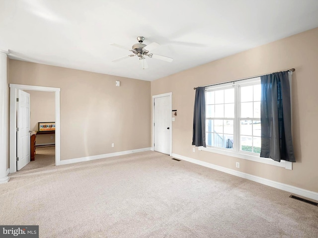 carpeted spare room with ceiling fan