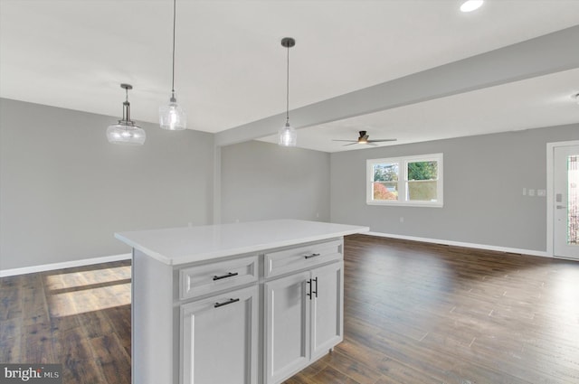 kitchen featuring white cabinetry, ceiling fan, a center island, dark wood-type flooring, and pendant lighting