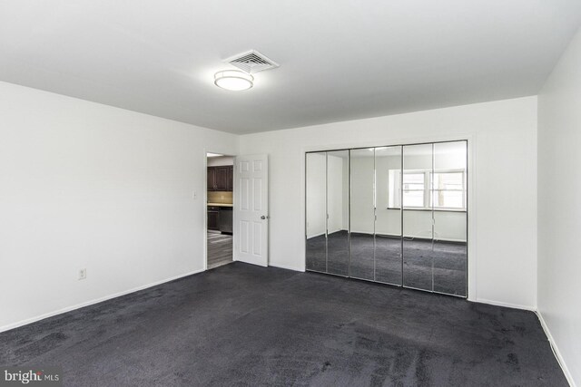 4624 Rhawn St, Philadelphia, PA 19136 - unfurnished bedroom featuring dark carpet, baseboards, and a closet