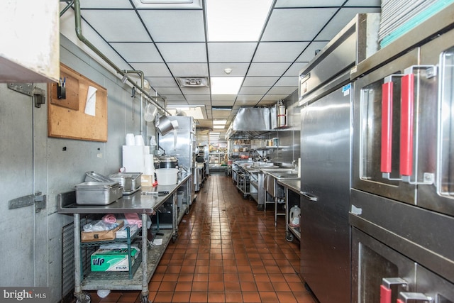 kitchen with dark tile patterned floors and a paneled ceiling