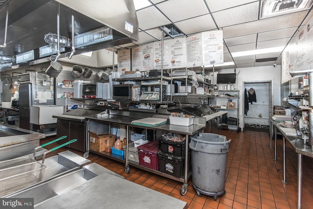 kitchen with dark tile patterned floors and a drop ceiling