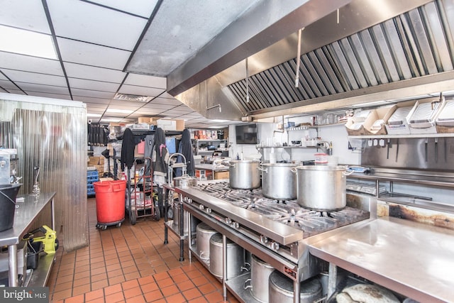 kitchen featuring a paneled ceiling, stainless steel counters, and tile patterned floors