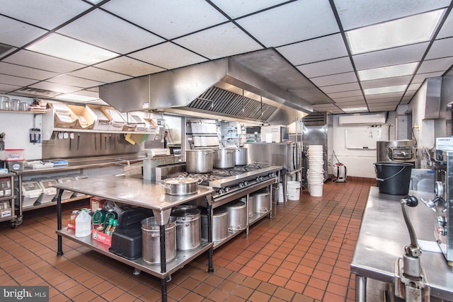 kitchen with a drop ceiling, dark tile patterned flooring, and stainless steel countertops