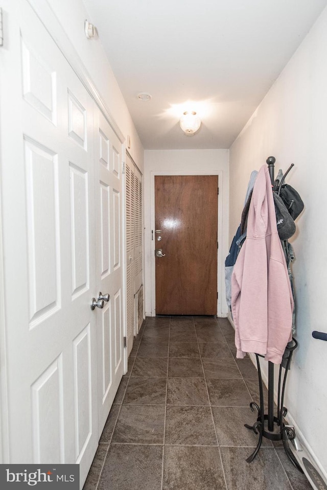 hallway featuring dark tile patterned floors